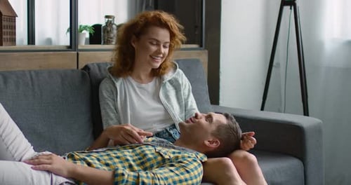 Young Sweet Couple Is Relaxing on a Sofa