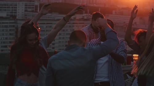 Friends Dancing at Rooftop Party During Sunset