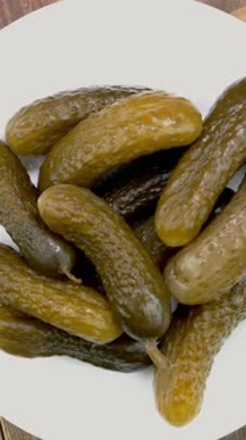 Homemade Salted Cucumbers Rotates in Plate on Wooden Background