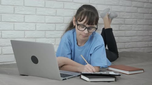 Webinar von zu Hause aus. Ein Schüler lernt von zu Hause aus mit einem Notizbuch.