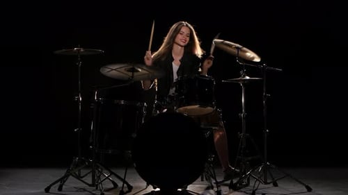Energetic Drummer Playing Drums in Dark Studio