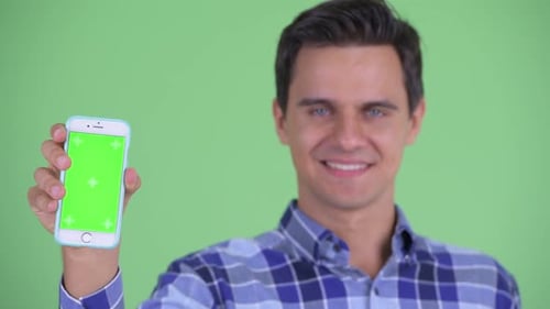 Young Adult Holding Up Phone With Green Screen