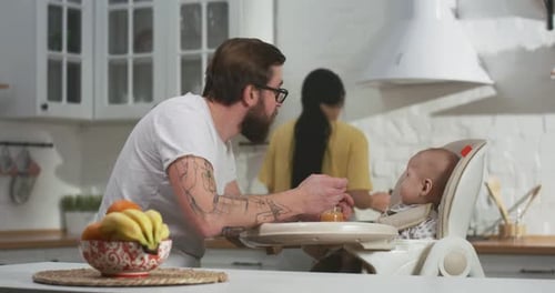 Family Feeding Infant in High Chair