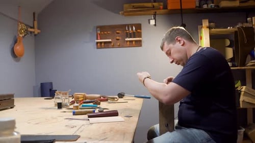 Tanner Sews a Needle Leather Product in the Studio. He Makes a Purse for Individual Design