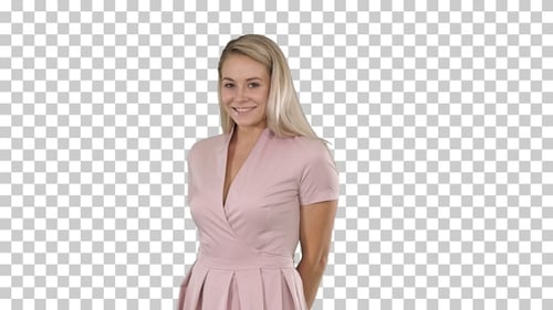 Beautiful woman in pink dress smiling to the camera being shy,