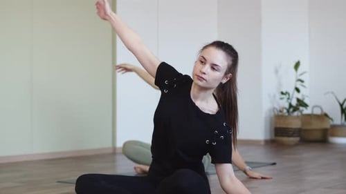Two Young Women Practicing Yoga in Studio