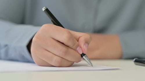 Nahaufnahme einer Afrikanerin, die mit Stift auf Papier schreibt