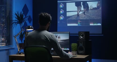 Joven sentado y editando Vídeo dentro de una habitación