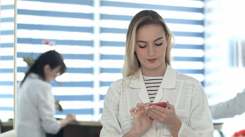 Woman Using Smartphone in Medical Office