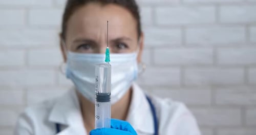 Health Professional Prepares Injection with Syringe