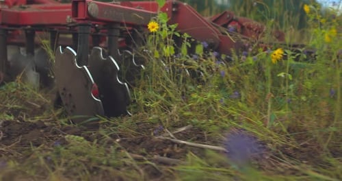 Tilling Equipment Moves Through Grassy Field