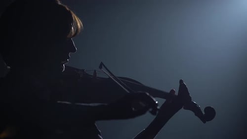 Violinist Performing in a Dark Studio with a Lantern