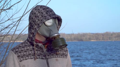 Adult with Gas Mask on By Blue Lake