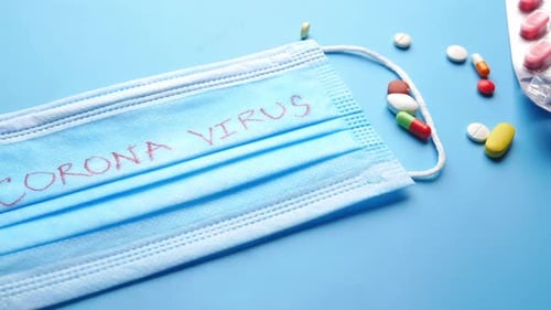 Close Up of Stethoscope Mask and Medical Pills on Blue