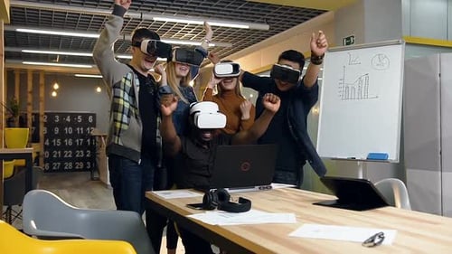 Young Adults Using VR Headsets Celebrating in Office