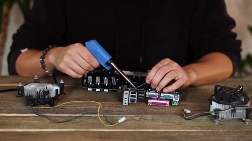 Computer Repair Using Soldering Iron on Motherboard