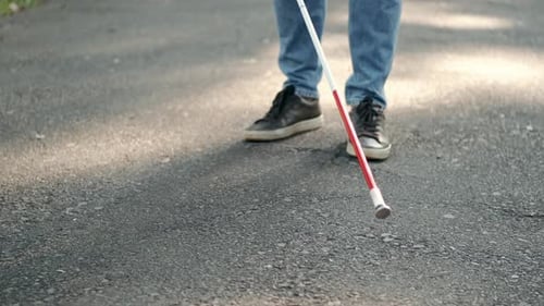 Junger blinder Mann geht im Park spazieren