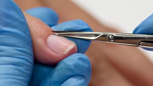 Manicurist Makes a Classic Manicure By Scissors. Close Up