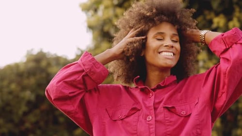 Smiling Woman with Curly Hair Outdoors