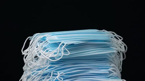 Stack of Blue Surgical Masks on Black Background