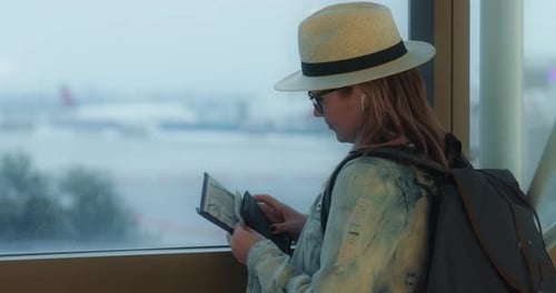 Woman with Backpack Putting Her US Passport Into the Travel Case in Airport