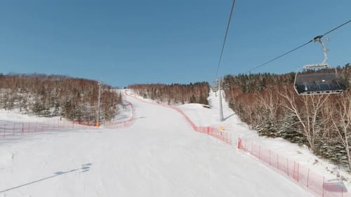 Riding on Ski Lift Above the Slopes in the Morning