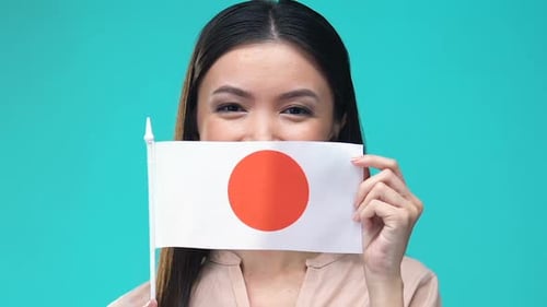 Young Woman Holding Japanese Flag and Smiling