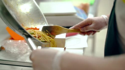 Chef Packing Takeout Noodles into a Box