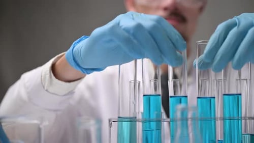 Scientist Removes Test Tube from Rack in Lab