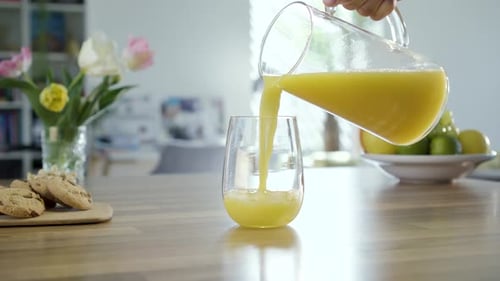 Pouring Fresh Orange Juice Into a Glass