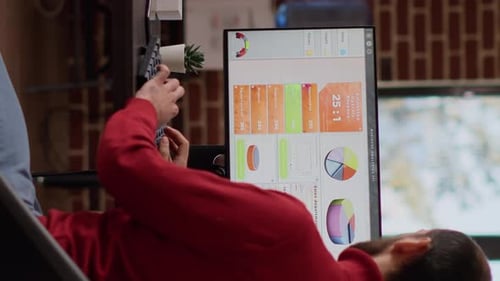 Analyst Reviewing Charts and Graphs on Computer Screen