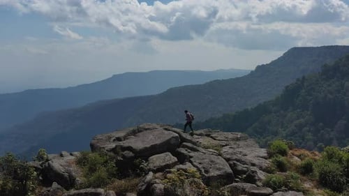 Drone view Young hiking man walking to peak of mountain