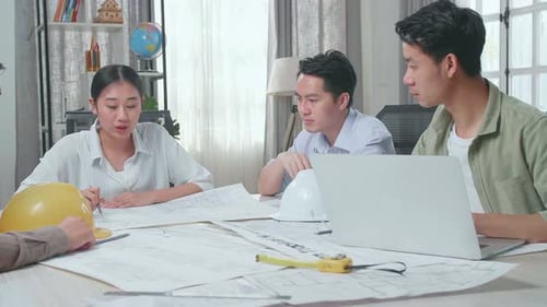 Group Of Asian Engineers Discuss About Work At The Office