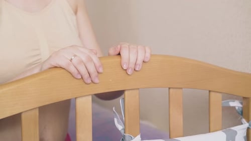 Pregnant Woman Gazing Lovingly at Baby Crib
