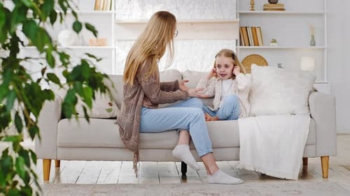 Woman and Child Chatting on Couch Indoors
