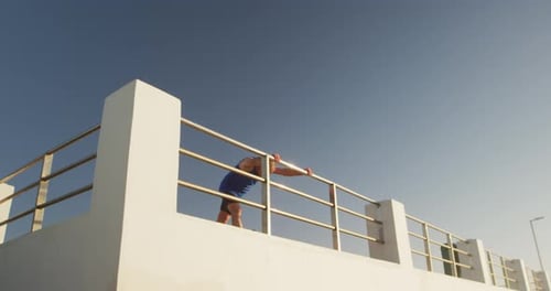 Senior man performing stretching exercise on the promenade