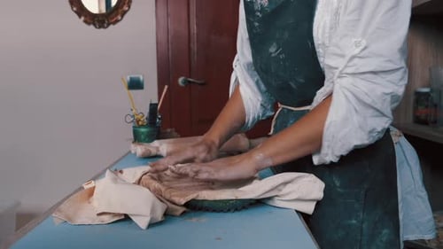Person Working with Clay in Studio Setting