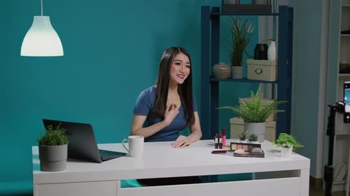 Influenciador asiático filmando video tutorial de maquillaje en estudio