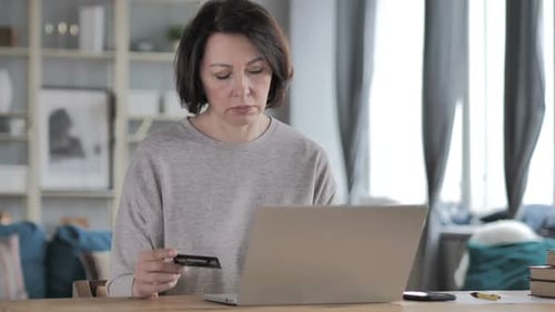 Woman Shopping Online with Credit Card on Laptop