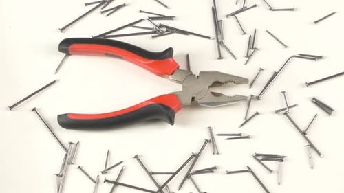 Pliers and Nails on White Surface