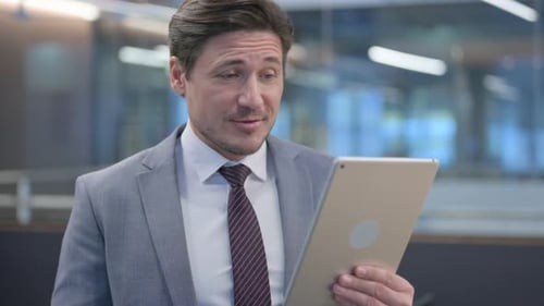 Man Talking on Tablet in Office Setting