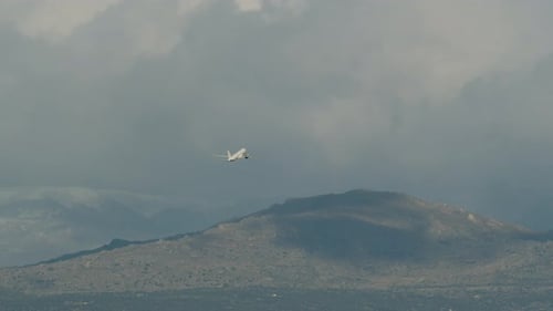 Airplane Flying Near Mountain on a Cloudy Day