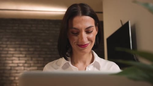 Woman Smiling While Working on a Computer
