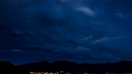 Night Time Lapse Over City and Mountains