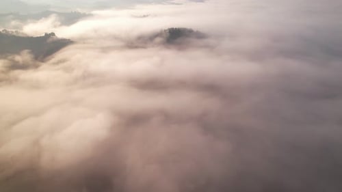 Rolling Fog Over Mountainous Landscape at Sunrise