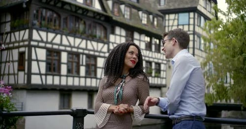 Happy Young Man and Woman Are Flirting and Embracing on Street of European City in Daytime
