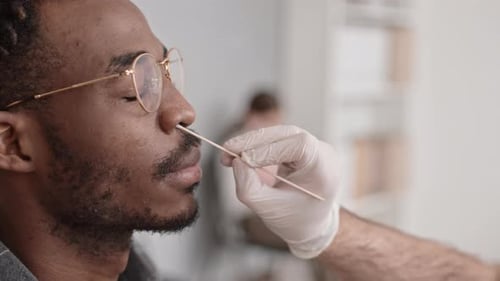 Man Receives Nasal Swab Test in Doctor's Office