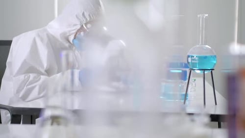 Medical Professional Works With Microscope in Bright Lab