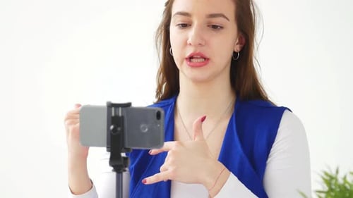 Smiling Woman Talking to Smartphone Camera on Tripod