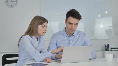 Young Professionals Collaborating on Laptop in Office